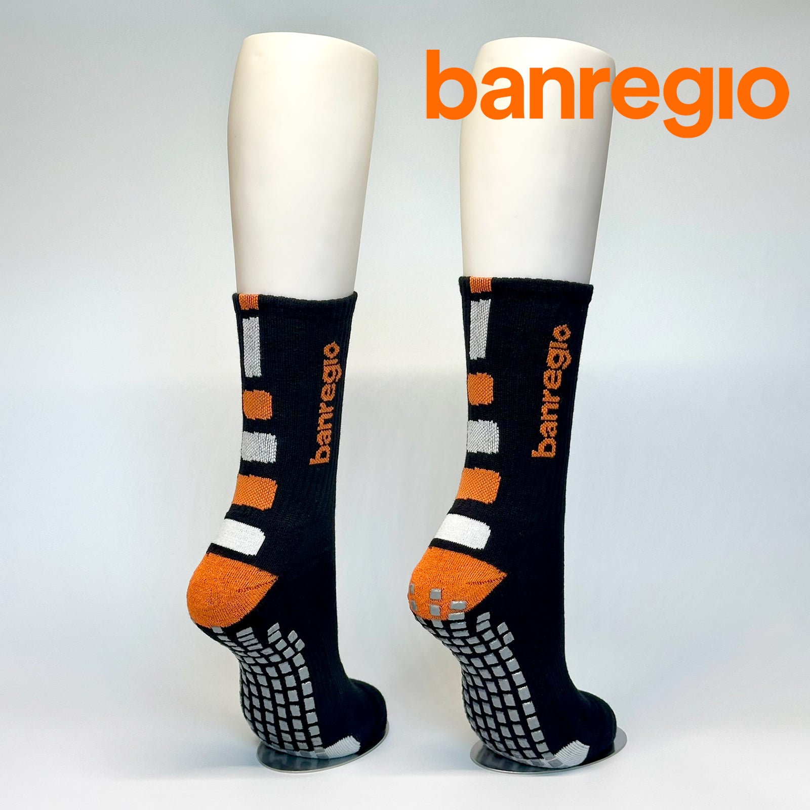 Calcetas personalizadas antidezlizantes color negro con detalles en blanco y naranja y el logo tejido de Banregio. Las regalaron a los empleados de banregio para promover el deporte en la empresa. 