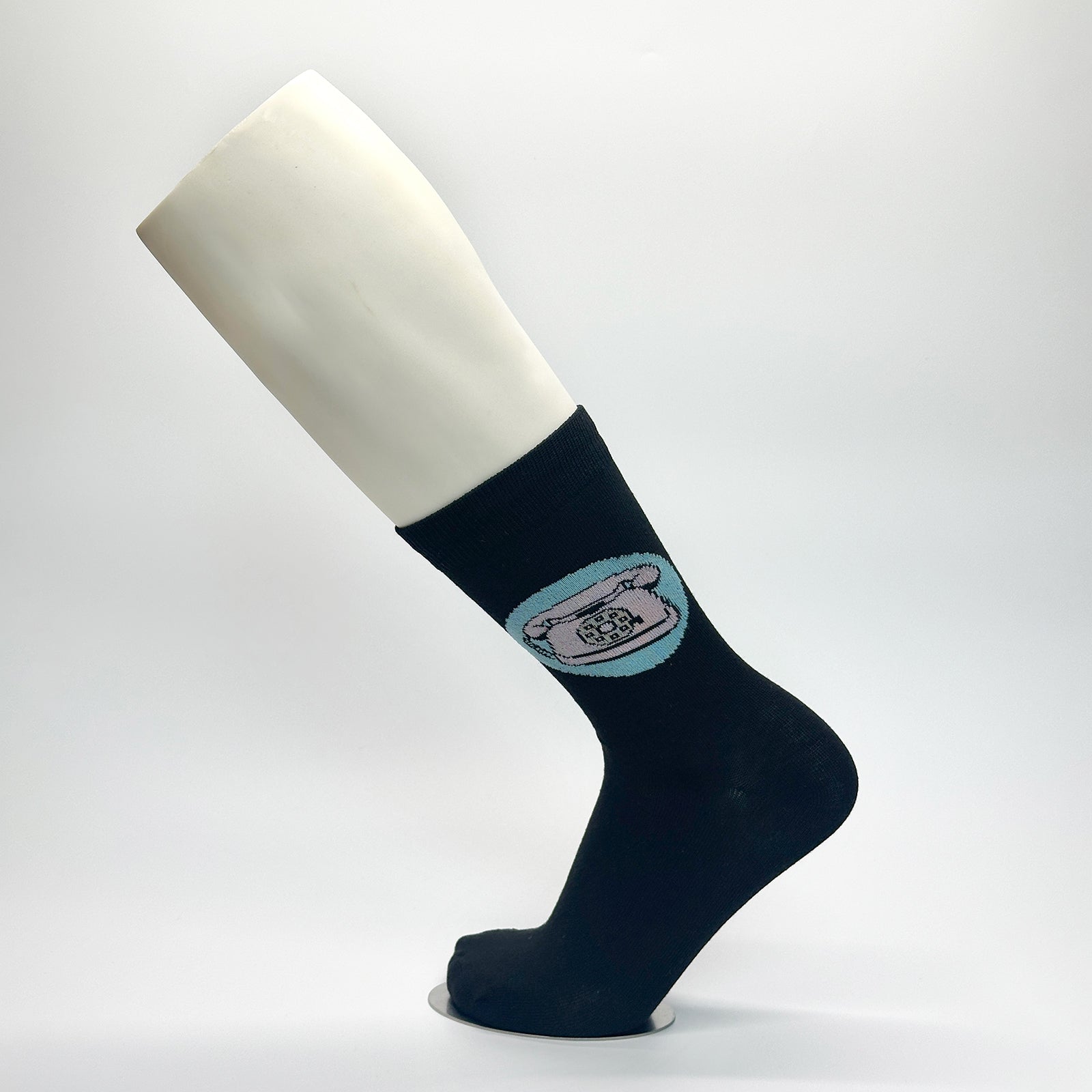 Calcetas personalizadas de vestir negras con icono de teléfono dibujado por un artista. El artista las repartió en la exposición de su arte. 