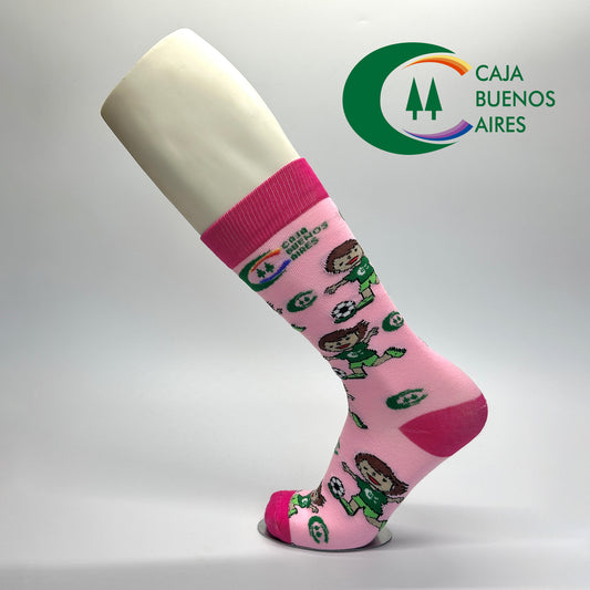 Calcetas personalizadas de vestir rosas con icono de niña jugando fútbol Soccer y logo de la empresa Caja Buenos Aires.