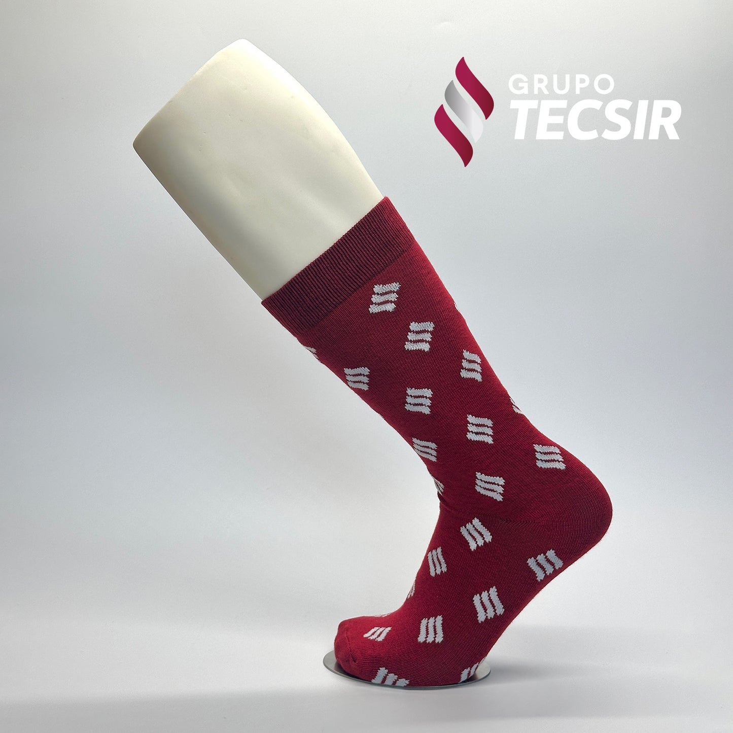 Calcetas de vestir personalizadas para Grupo Tecsir. Las calcetas tienen un diseño de fondo rojo con un patrón del logo de Grupo Tecsir en blanco. 