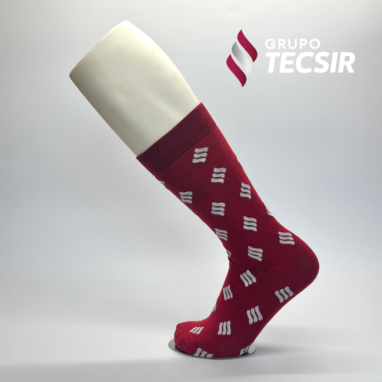 Calcetas de vestir personalizadas para Grupo Tecsir. Las calcetas tienen un diseño de fondo rojo con un patrón del logo de Grupo Tecsir en blanco. 