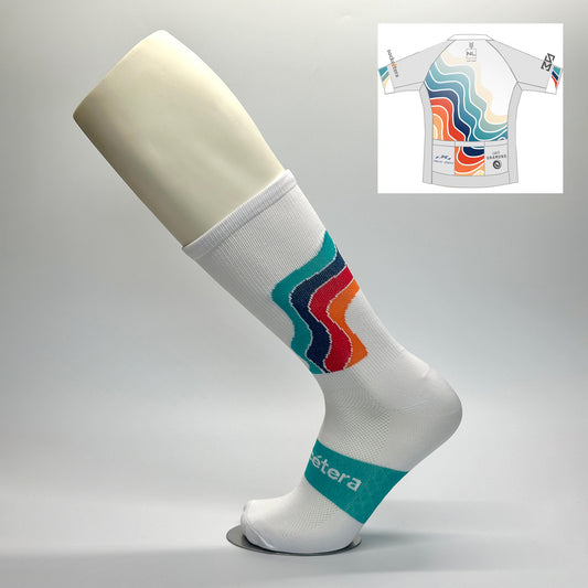 Calcetas personalizadas de ciclismo blancas con logo ilustración de equipo de ciclismo NL CYCLING en colores aqua, azul, rojo y naranja así como el logo SOCKCETERA en el empeine. Además vemos el jersey del equipo para ver la relación.