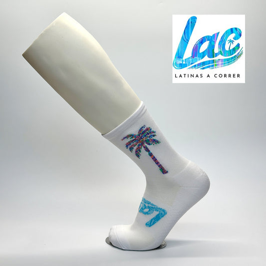 Calcetas personalizadas deportivas con diseño en fondo blanco y con muchos colores. La calceta tiene el logo de la carrera Latinas a Correr así como el logo de los organizadores. La calceta fue parte del kit de la carrera. 