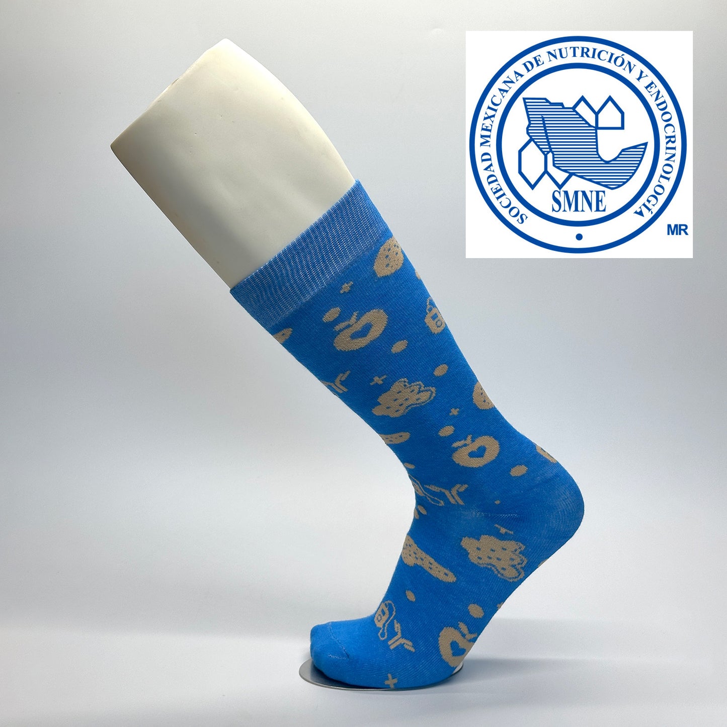 Calcetas personalizadas de vestir azules con patrón beige de iconos relacionados con la medicina. Calcetas para expo de la sociedad mexicana de nutrción y endocrinología.